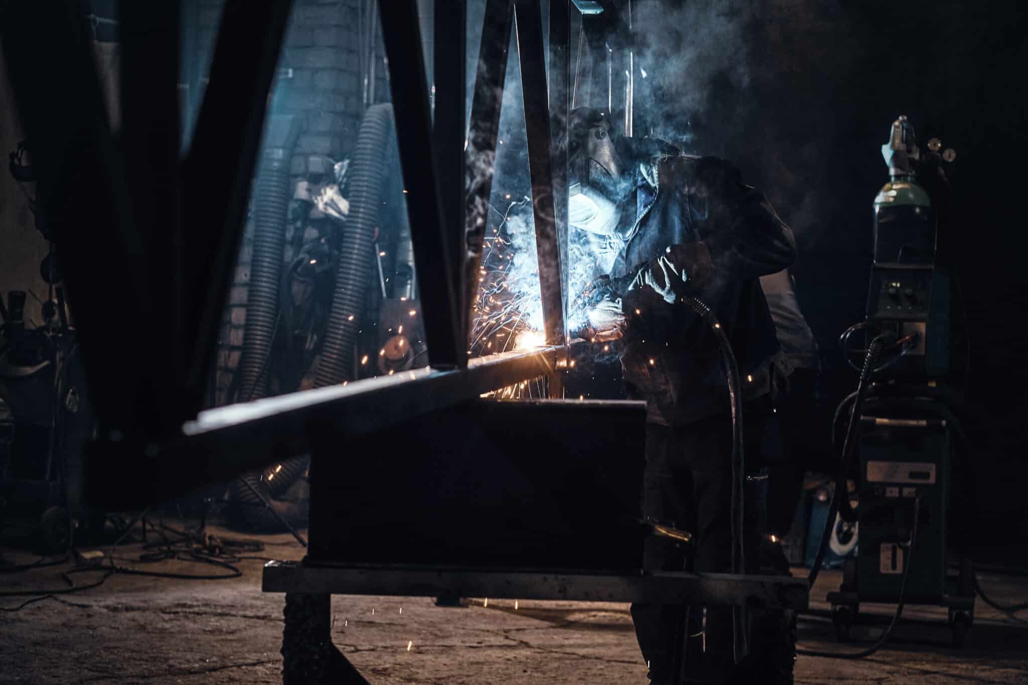 Worker welding steel pieces together